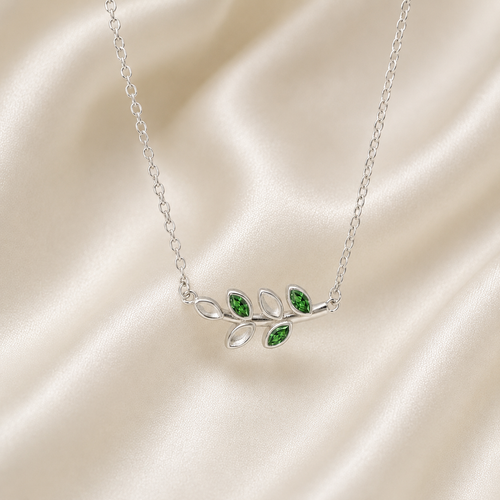 925 sterling silver leaf necklace with emerald green CZ birthstone accents on cream satin