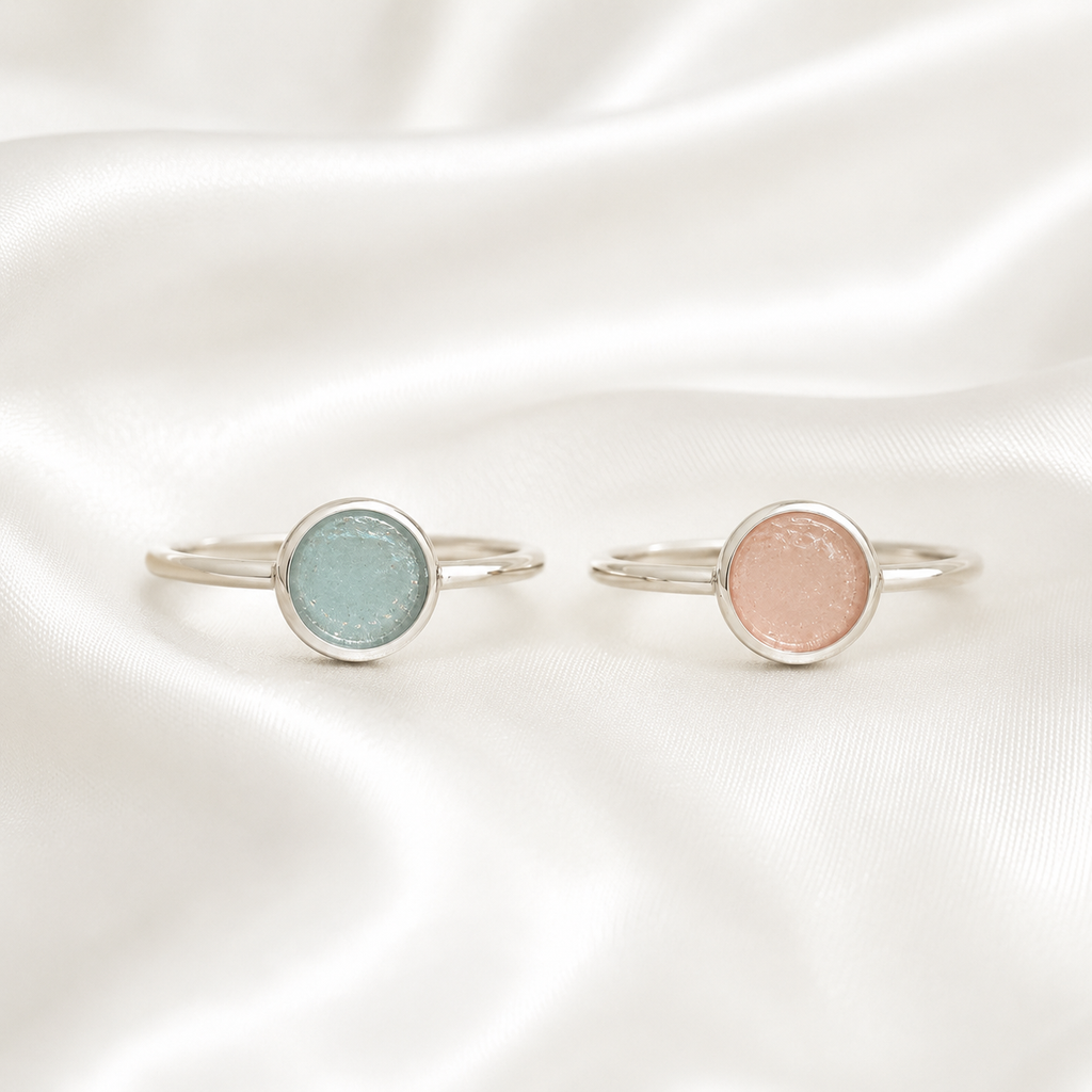 Silver round ring settings with blue and pink resin on white satin