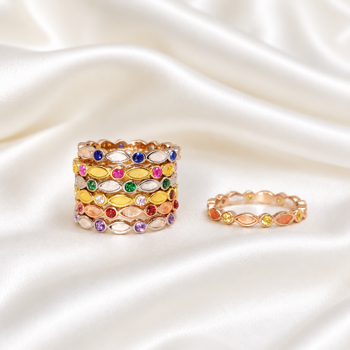 Stacked 925 sterling silver birthstone eternity band rings in rose gold, yellow gold and silver with colorful CZ stones on white satin