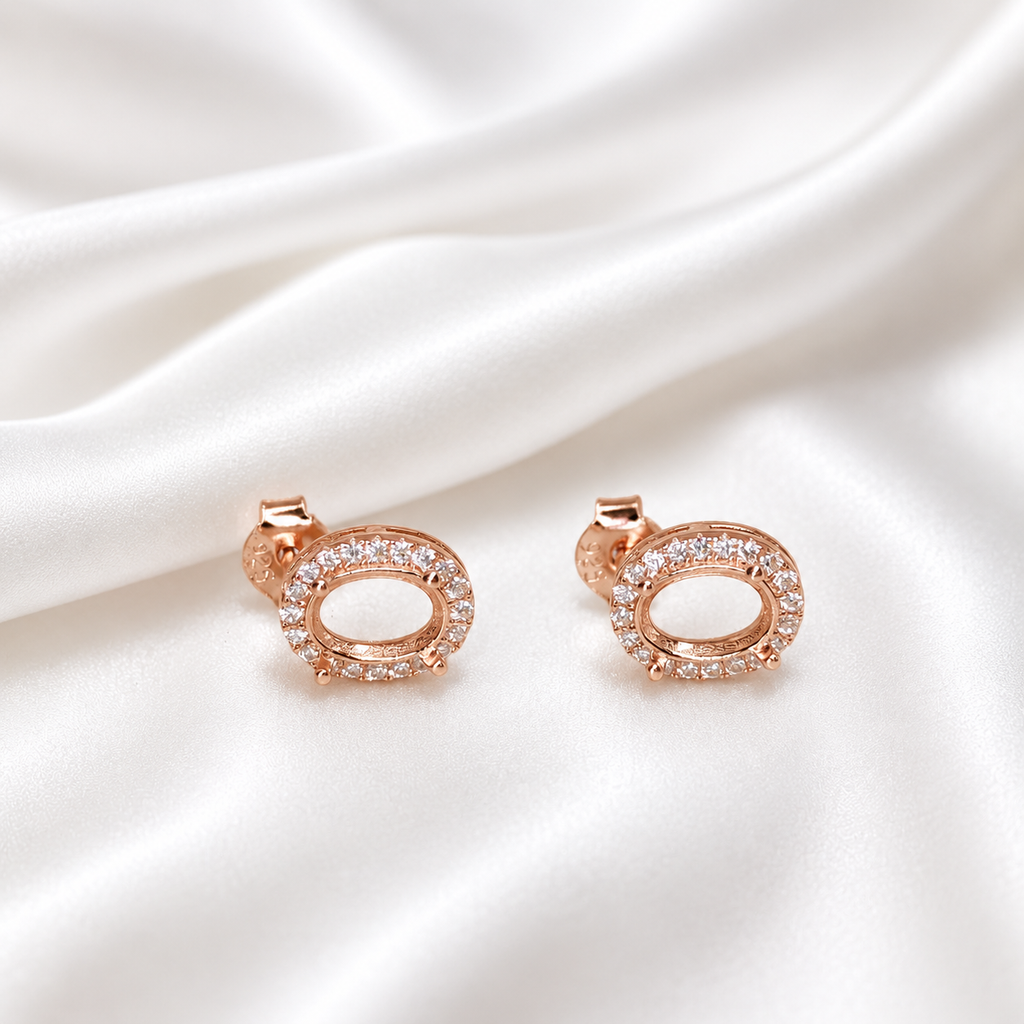 925 Sterling Silver and rose gold halo oval stud earring settings side by side on white satin