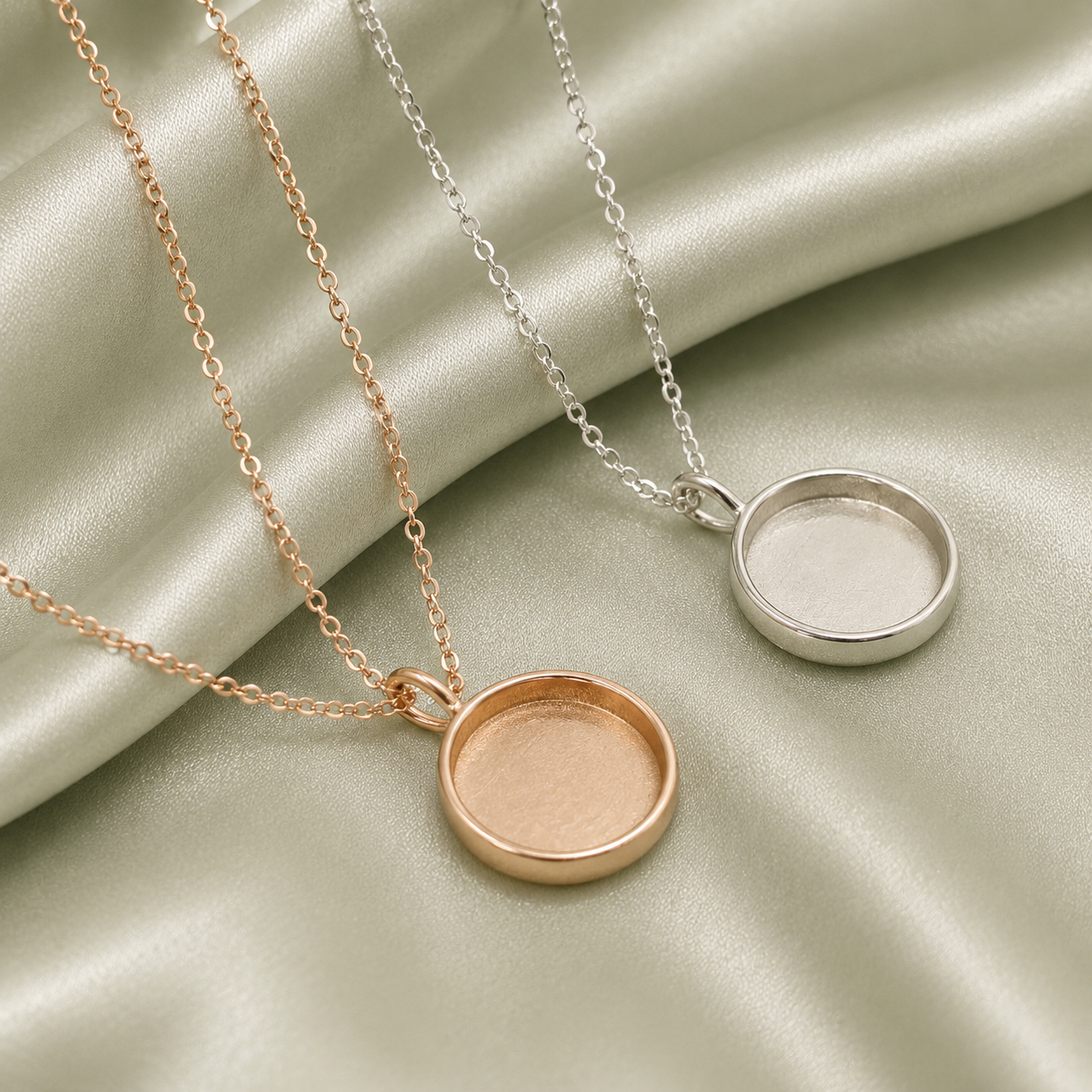 Rose gold and silver 925 sterling silver round blank necklace settings on sage green satin fabric