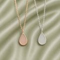 Rose gold and silver 925 sterling silver teardrop necklace settings on sage green satin fabric