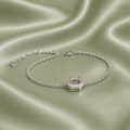 925 sterling silver halo round blank bracelet setting with CZ surround on sage green satin fabric