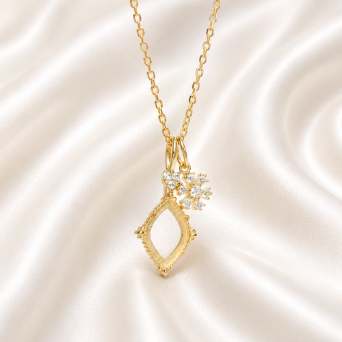 Gold diamond shape vintage necklace setting with CZ snowflake charm on white satin - front view