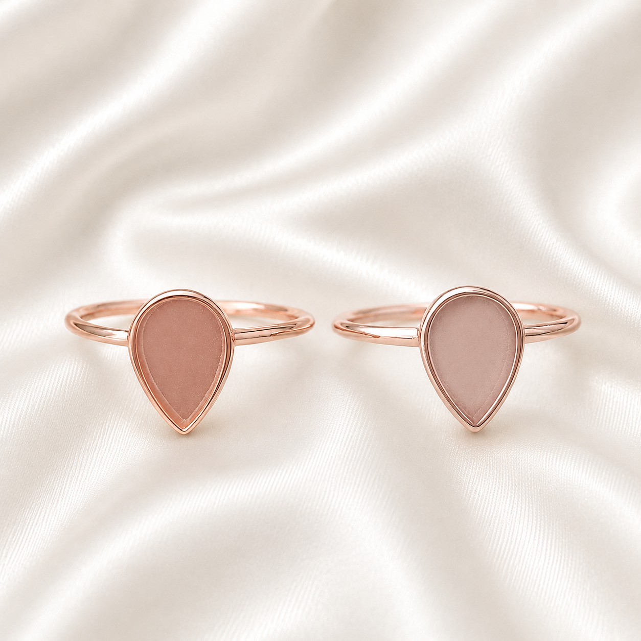Rose gold teardrop ring settings with pink stone on white satin