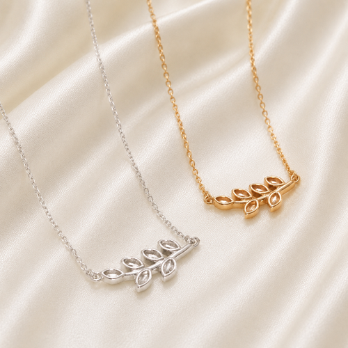 925 sterling silver and gold birthstone leaf necklaces with open marquise bezels on cream satin