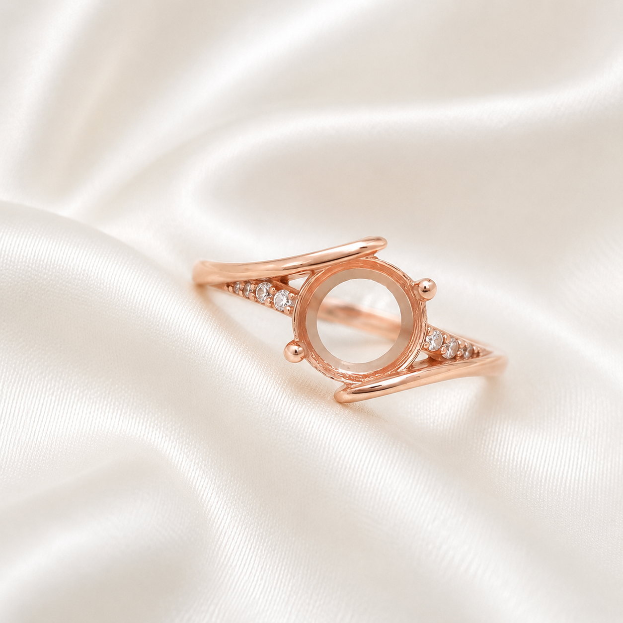 Rose gold 925 sterling silver round open bezel split shank ring setting with CZ accents on cream satin - angle view